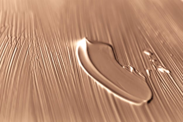 A close-up shot of various skincare product textures (serum, moisturizer, oil) side-by-side, visually representing the concept of layering from lightest to thickest.