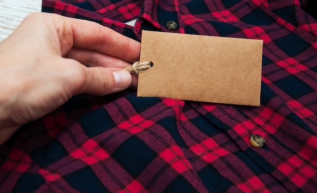 A hand holding a tag on a garment in a thrift store, clearly showing the fabric composition as 