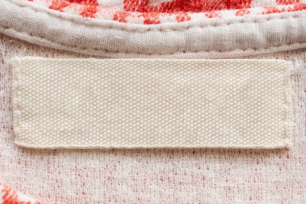 A close-up of a label inside a vintage wool coat in a thrift store. The label specifies the fabric content (100% Wool) and origin (Made in Italy). The shot is well-lit to highlight the details.