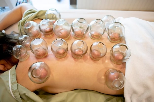 A therapist is carefully placing a row of silicone cups down a client's spine. The therapist is gloved and focused on precision, while the client lies comfortably on a massage table, ready to receive the cupping treatment.