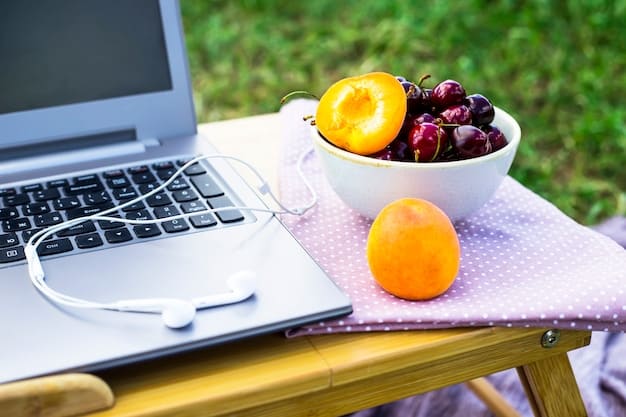 A person's desk with a reusable water bottle, a bowl of fresh fruits (watermelon, strawberries, oranges), and a laptop. The scene suggests a healthy, hydrated work environment.