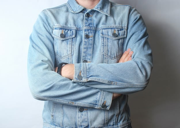 A close-up shot of a person wearing a light-wash denim jacket paired with dark-wash jeans. The focus is on the texture contrast between the two denim washes and the subtle details of the jacket and jeans (e.g., stitching, buttons). The background is blurred to keep the attention on the denim combination.