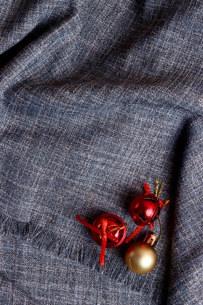 A close-up shot of different fabrics and textures, including denim, knit sweaters, scarves, and leather accessories. The color palette features warm, earthy tones such as beige, brown, olive green, and burgundy, illustrating the materials and colors ideal for transitioning from summer to fall.